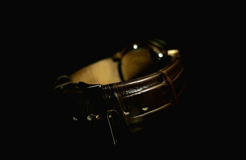 a brown leather watch band with a black background